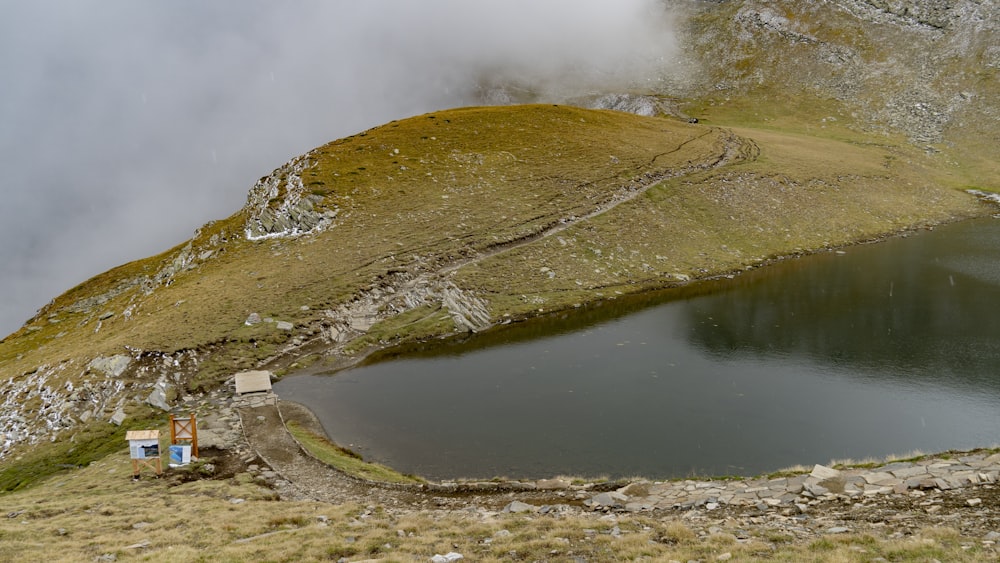 a body of water with a hill in the back