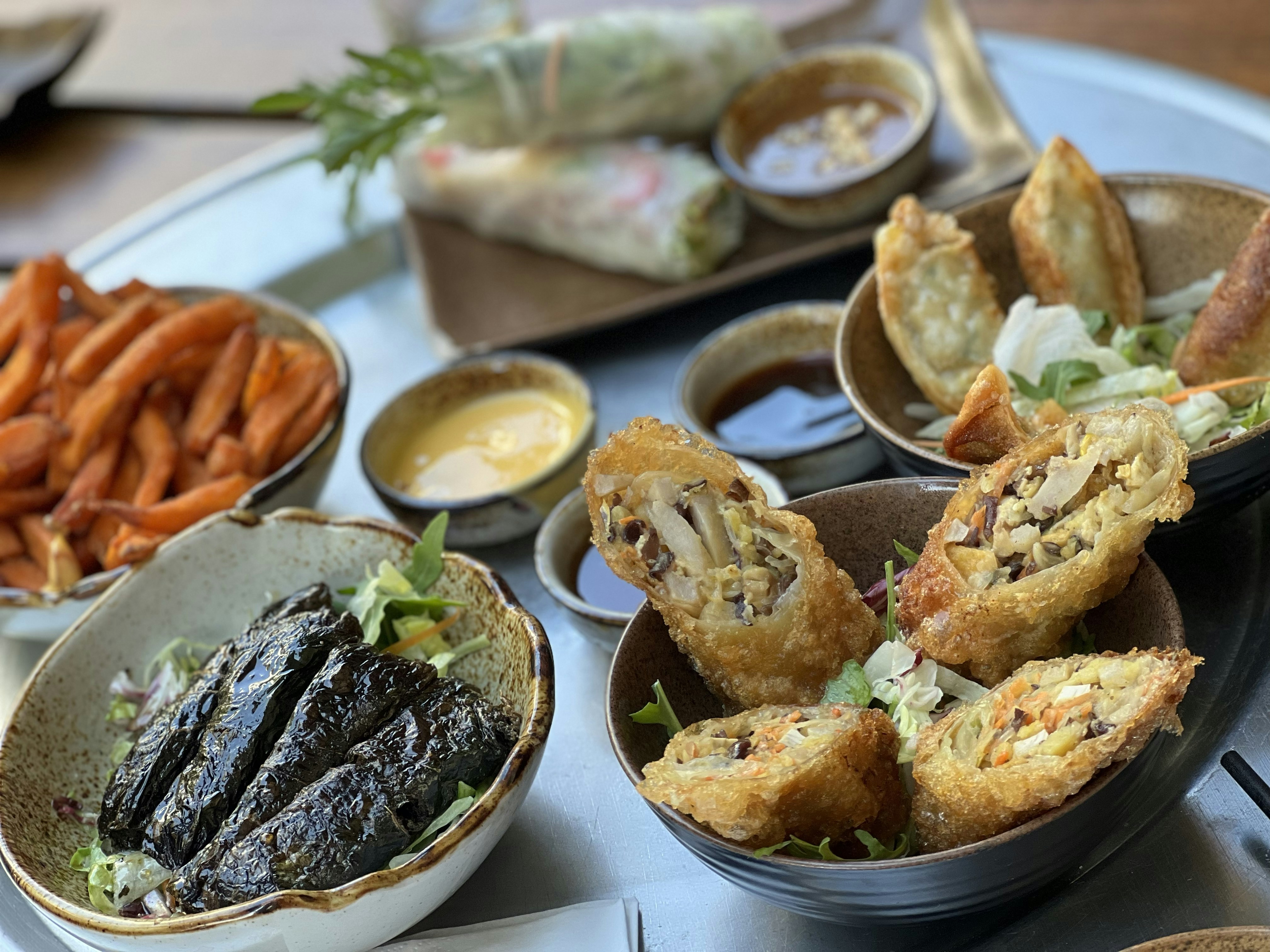 Table of fried spring rolls and shared dishes