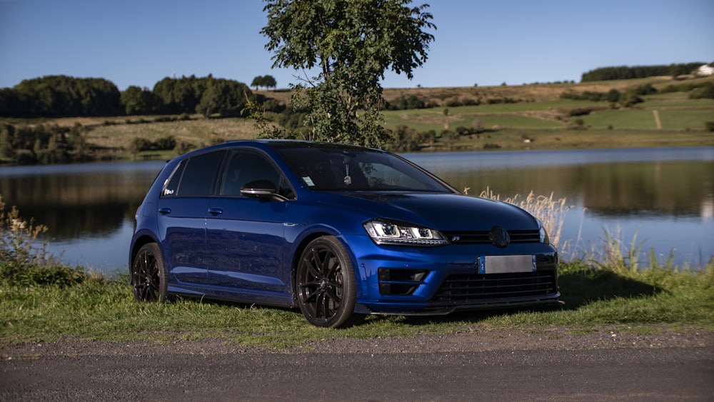 a blue car parked by a lake