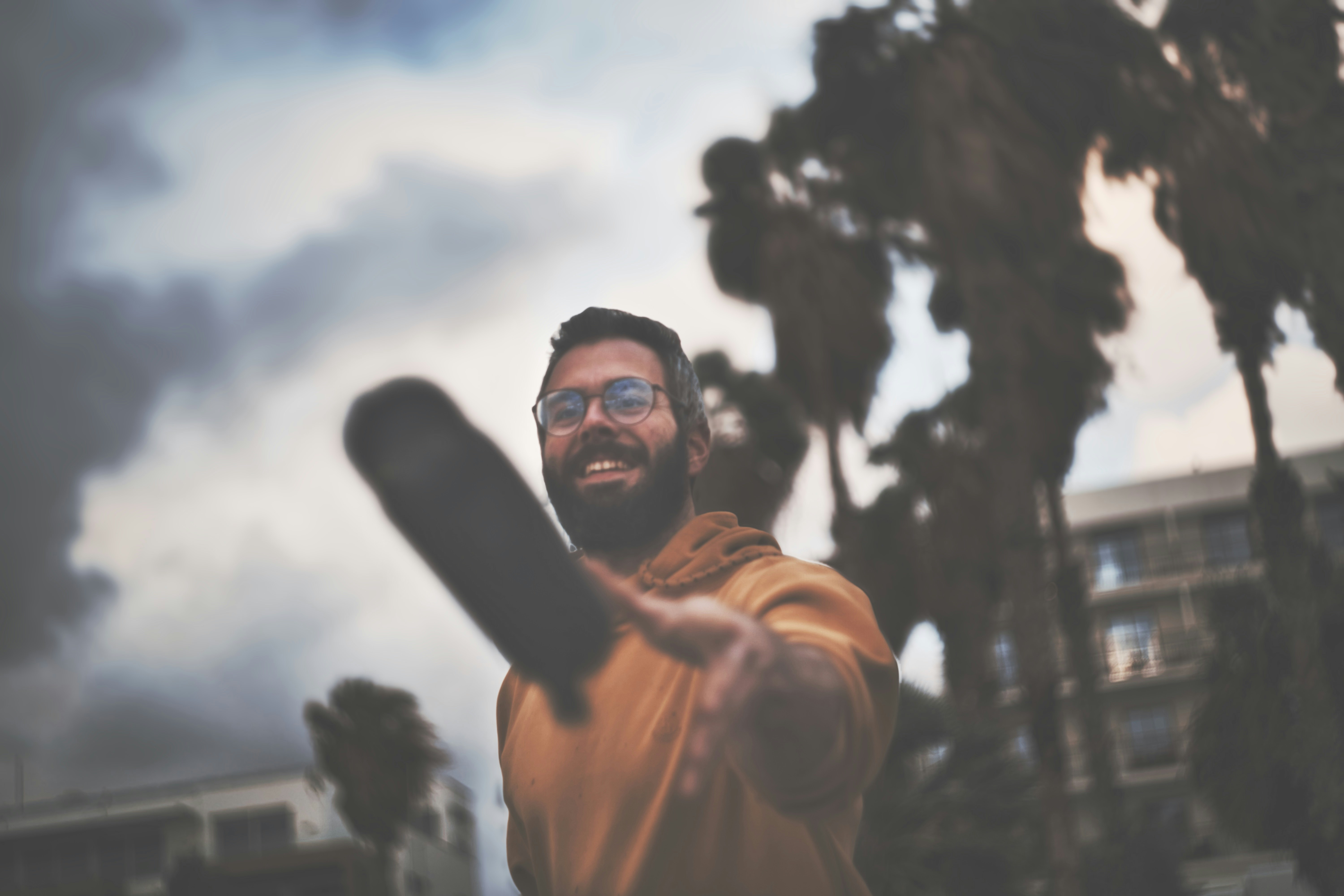 A man smiles while holding a bat.