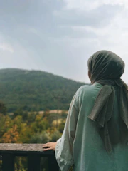 a person standing on a balcony overlooking a forest