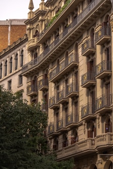 a building with balconies and trees in front of it