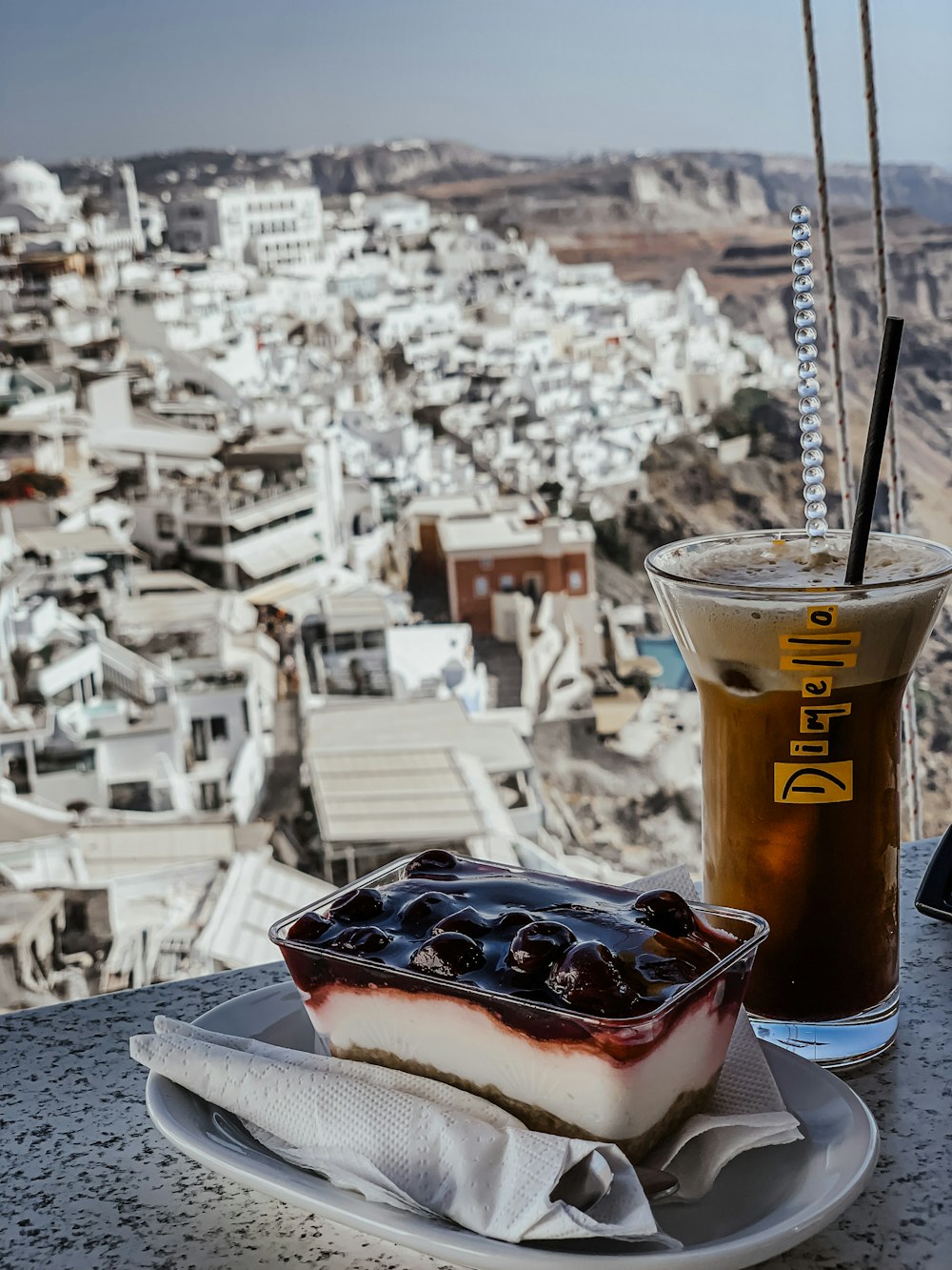 a dessert with a drink and a city in the background