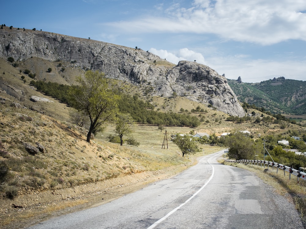 a road with trees and mountains in the background