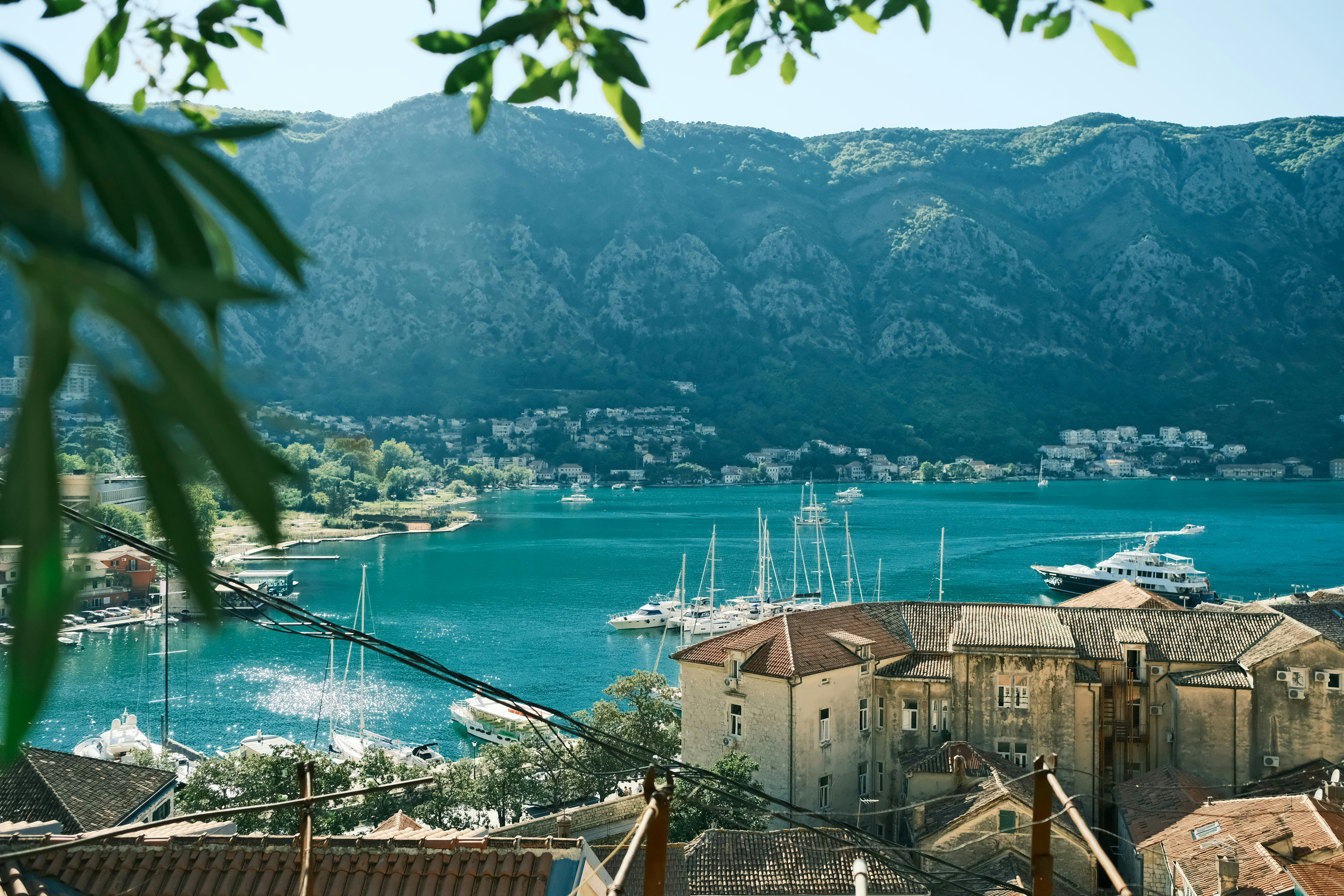 a body of water with boats in it and mountains in the background
