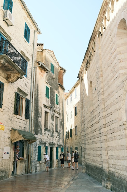 people walking on a street between buildings