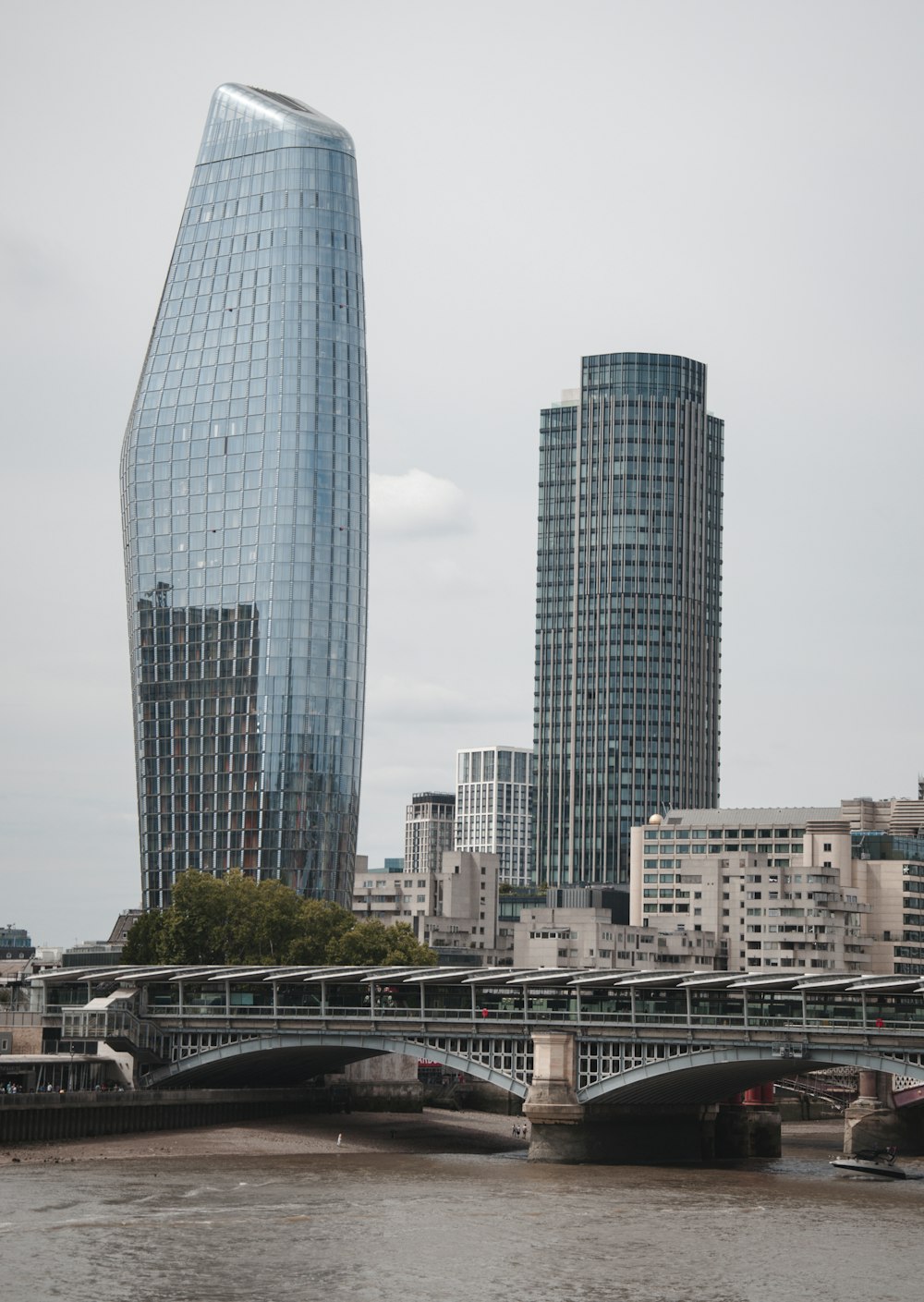 a bridge over a river with tall buildings in the background