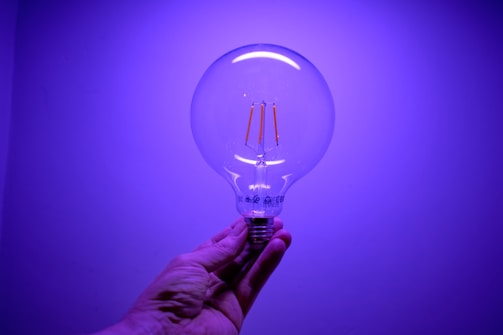 a hand holding a light bulb