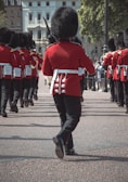 a person in a red coat walking in a parade