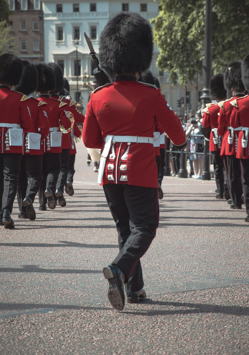 a person in a red coat walking in a parade