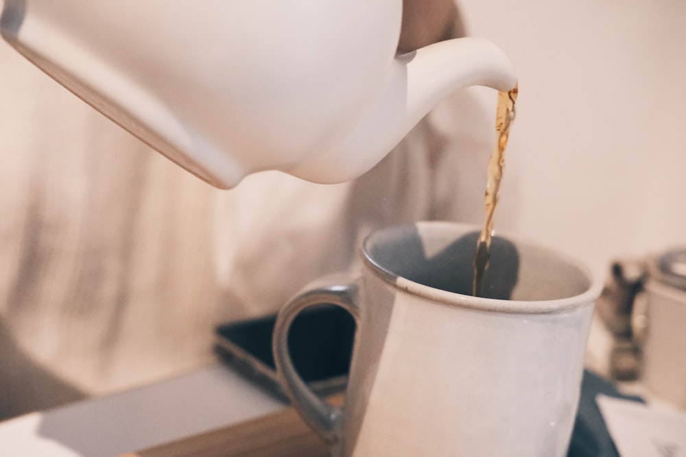 a person pouring a liquid into a cup