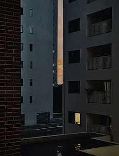 Modern apartment building with balconies and city views at sunset.
