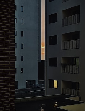 Modern apartment complex in a bustling US city skyline at sunset.