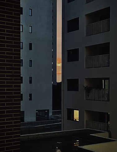 Wide shot of a modern apartment building exterior at sunset.