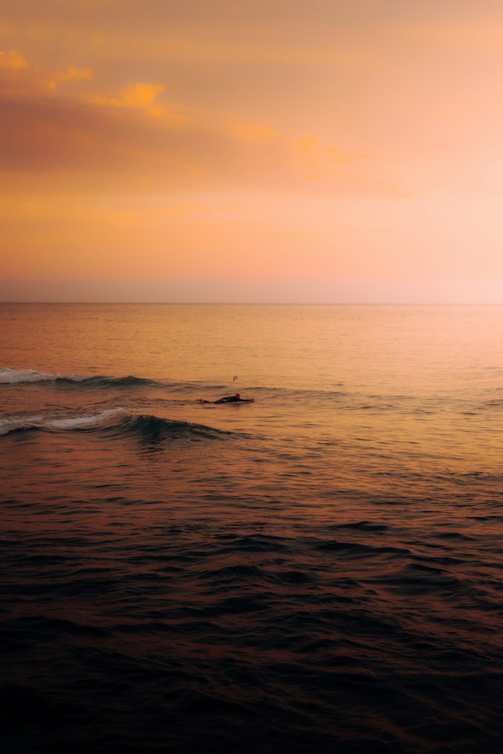 a body of water with waves and a sunset