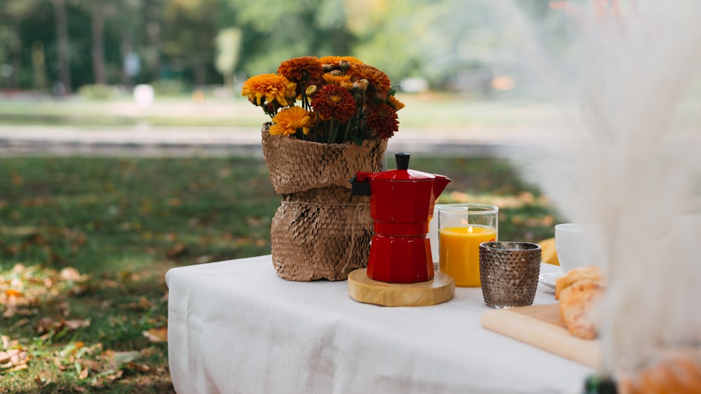 a table with a vase of flowers and a candle on it