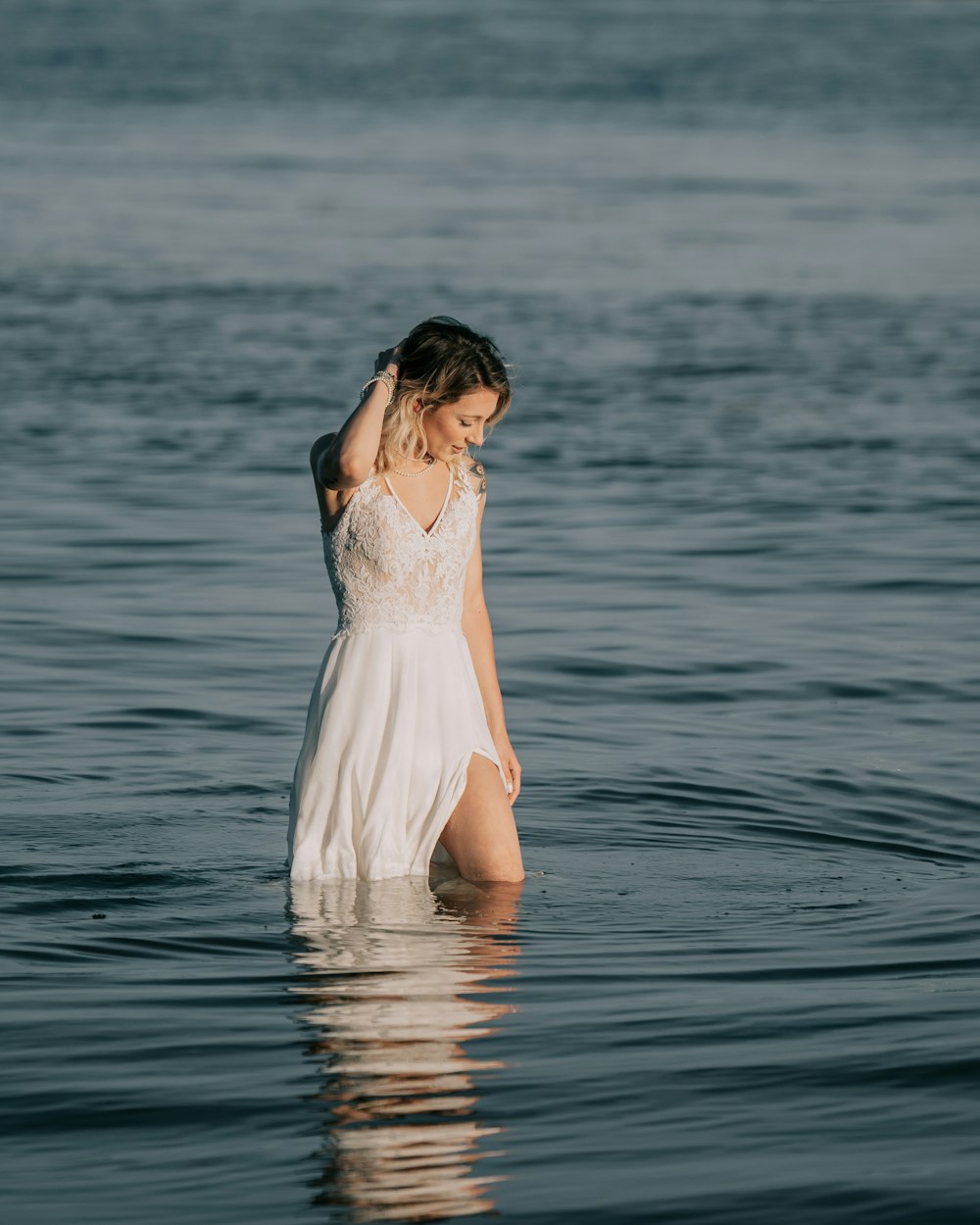 a person in a white dress standing in water