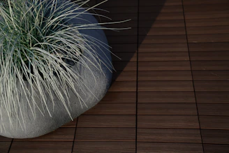 A modern Scandinavian-style planter holding a small herb garden, illuminated by natural light with smooth shadow gradients.