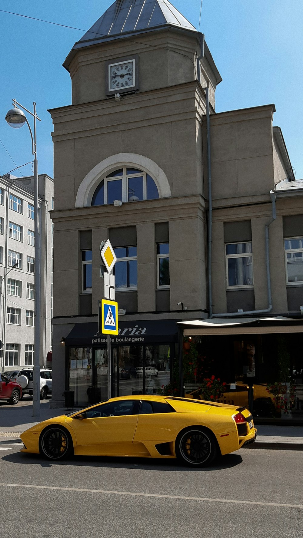 a yellow sports car parked in front of a building