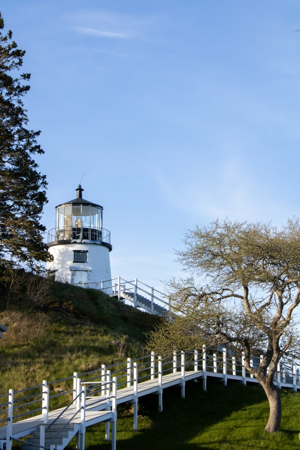 a white lighthouse on a hill