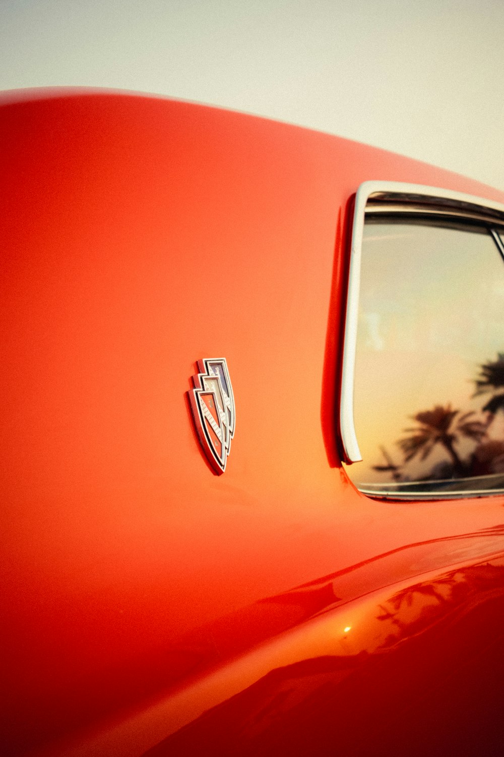 a red car with a palm tree in the background