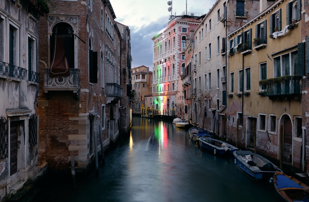 a canal with boats in it with Venice in the background