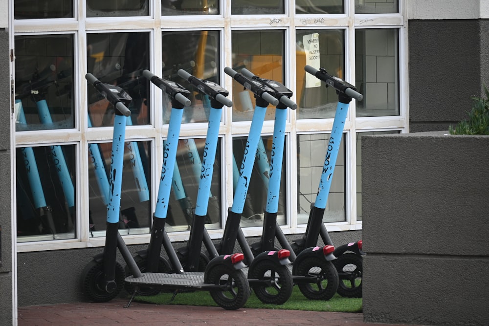 a group of blue and white scooters in front of a building
