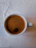 Close-up of a steaming espresso cup on a matte black surface with golden accents.