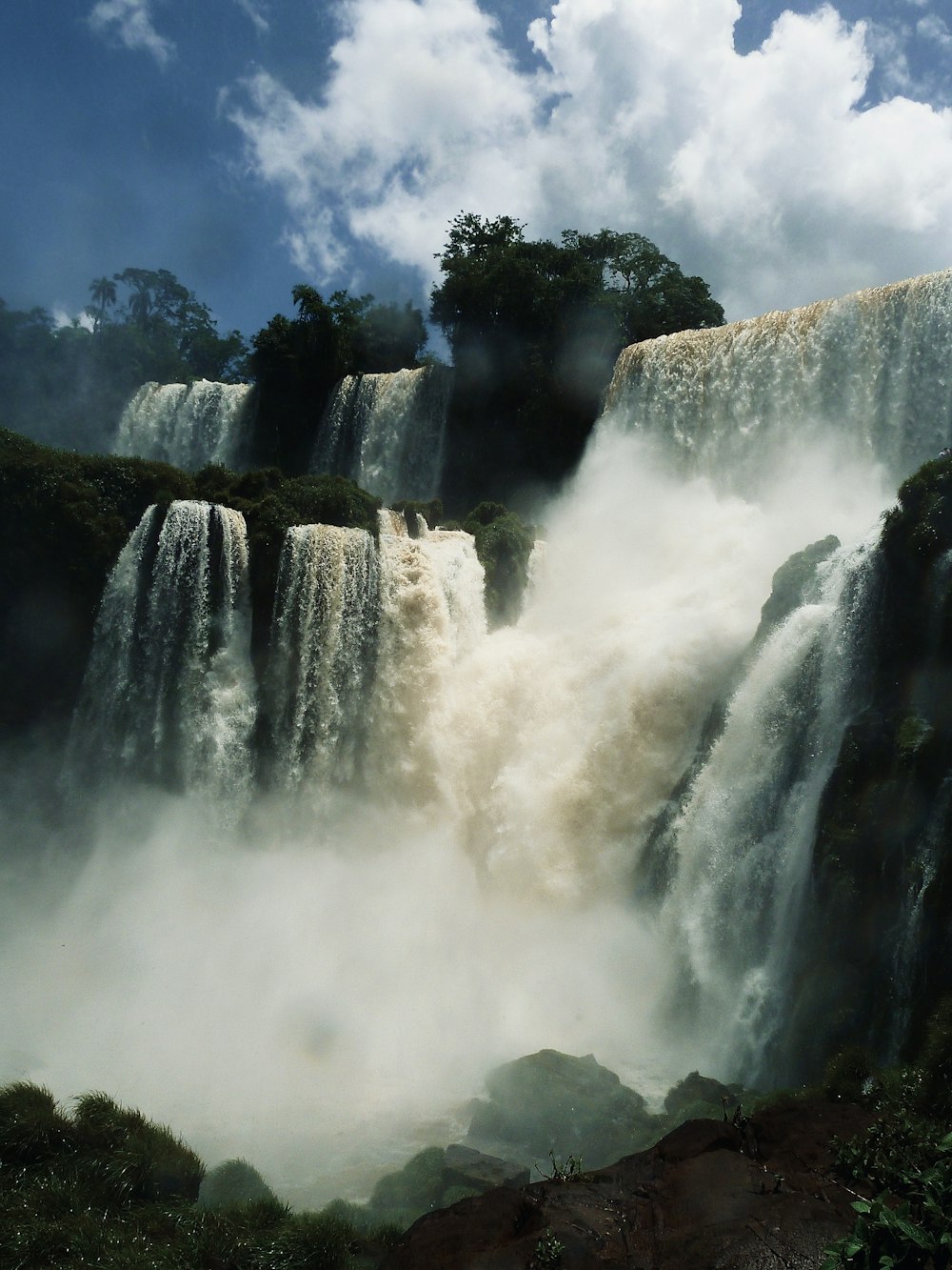 uma grande cachoeira com árvores e céu azul