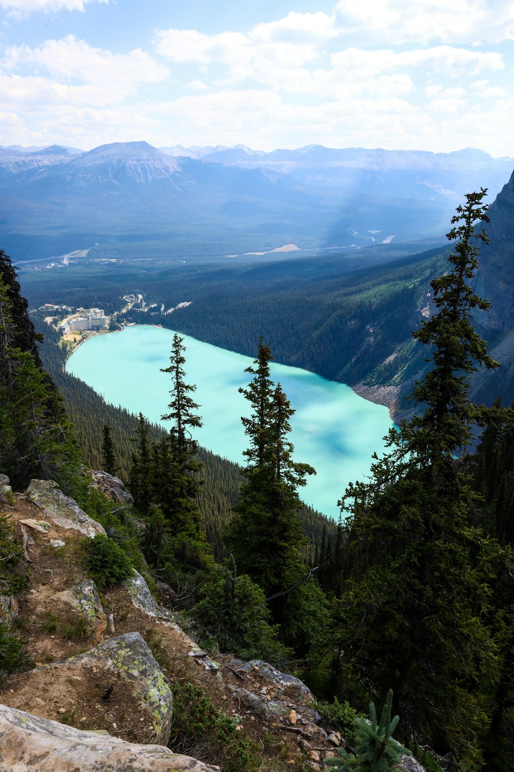 a view of a valley with trees and mountains in the background