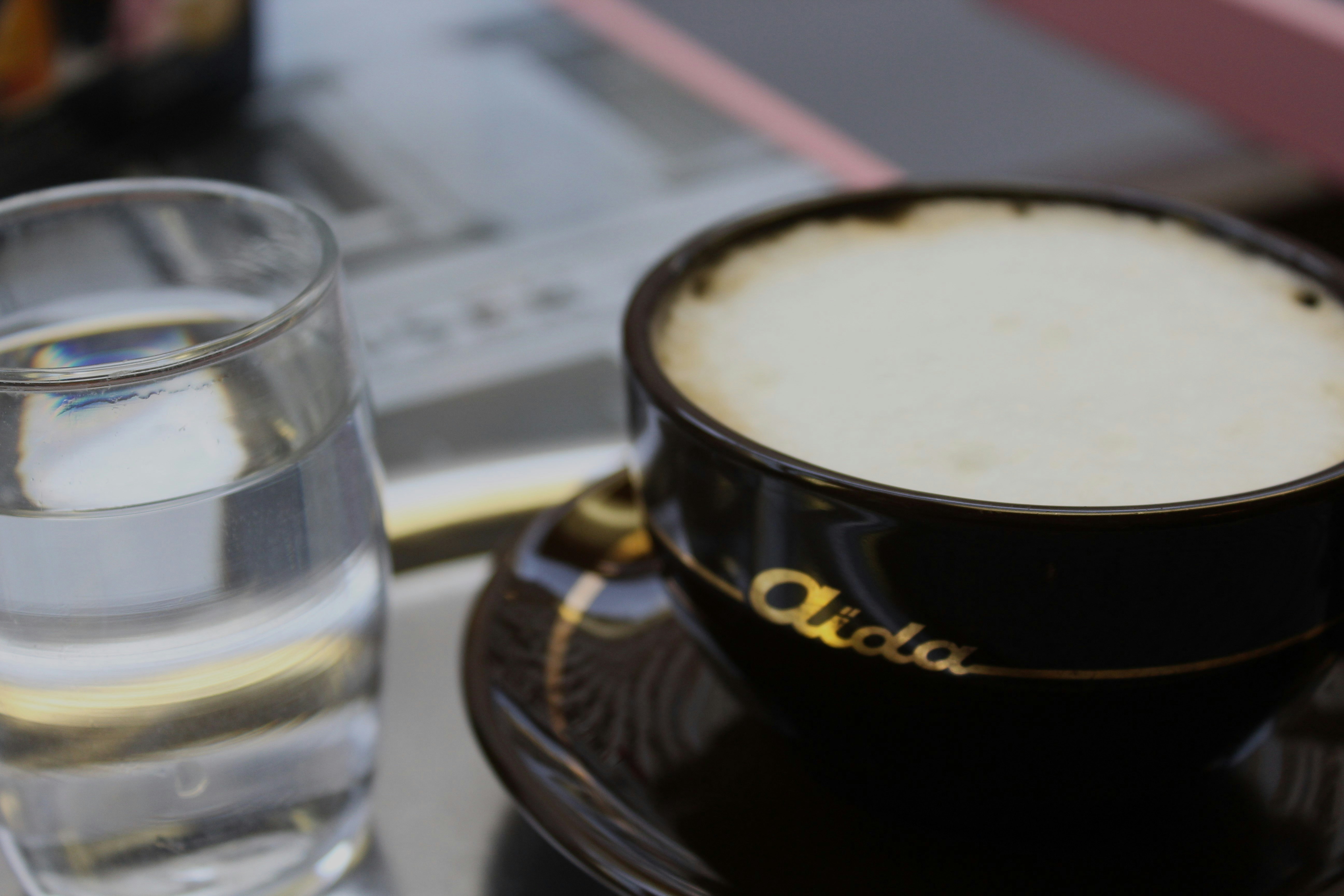 a glass of liquid and a glass of water on a coaster