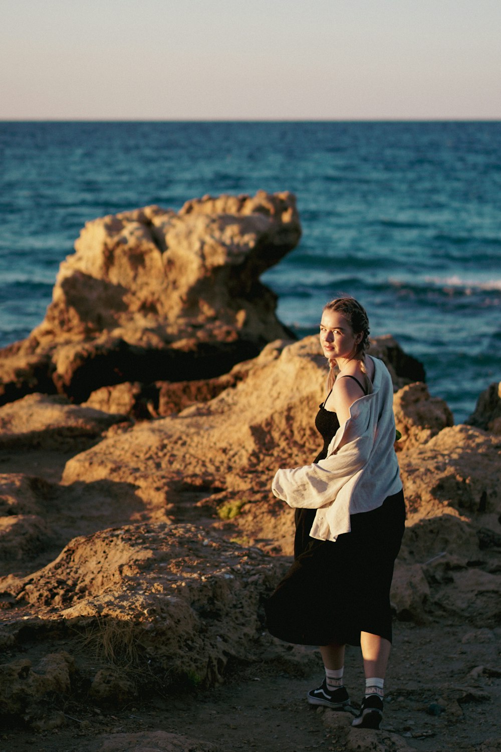 a person standing on a rocky beach