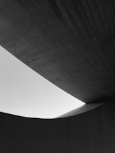 A striking architectural structure with bold lines and textured surfaces under warm, natural light.