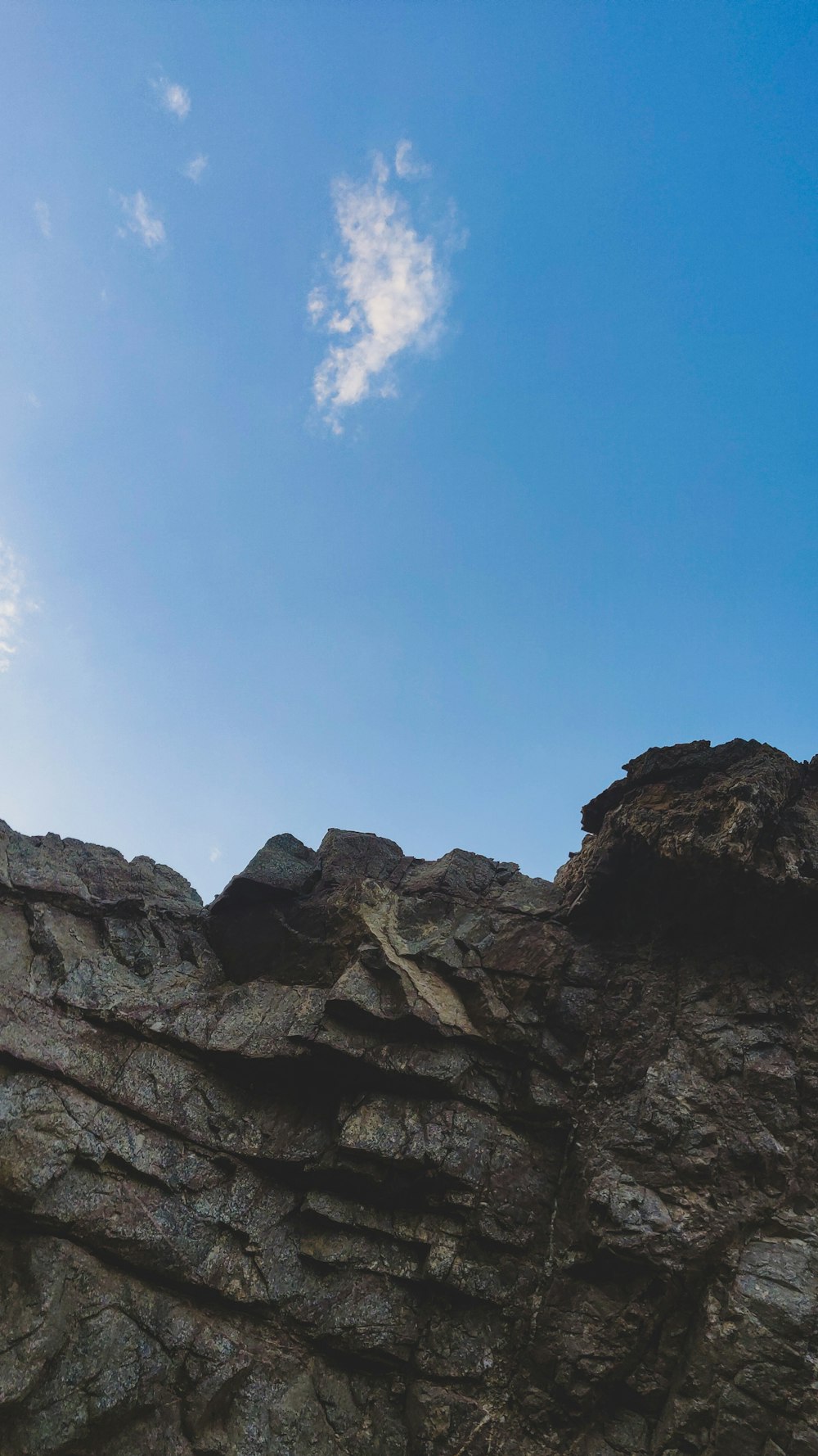 a rocky mountain with a blue sky