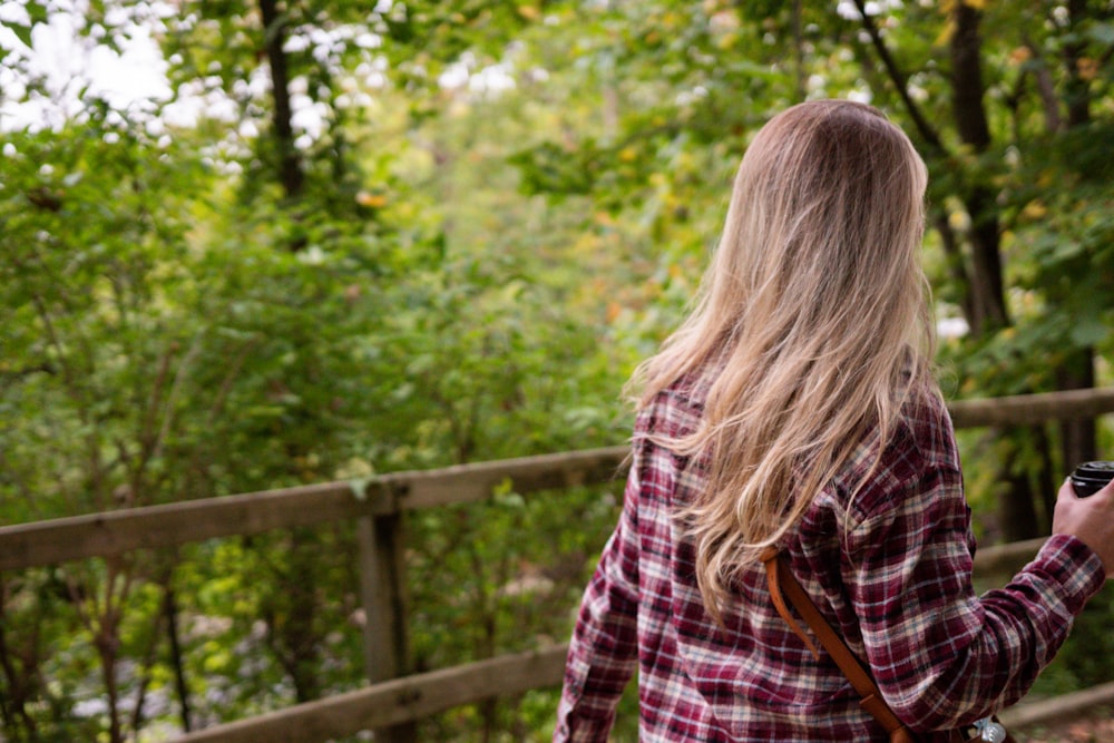 a woman taking a picture of a fence