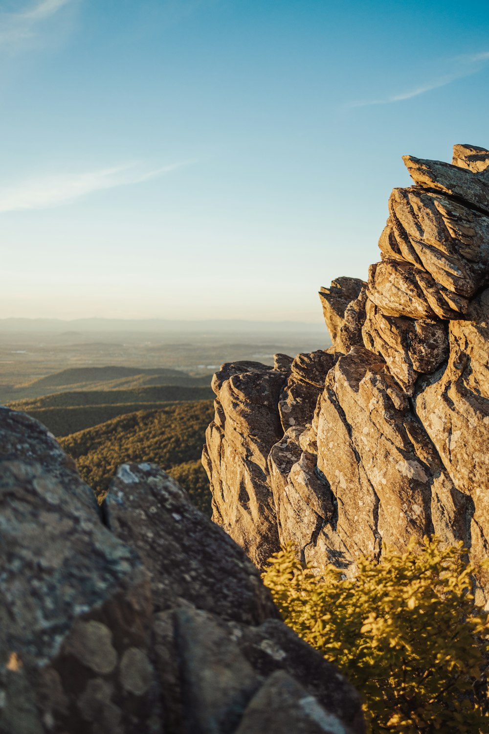 a rocky cliff with a valley below