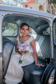 The bride and her escort stepping gracefully into the modern electric taxi, surrounded by soft floral decor.