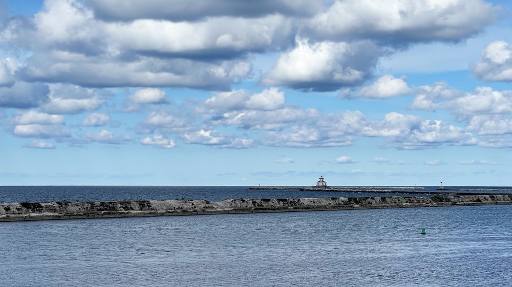 a body of water with a land with rocks and a boat in it