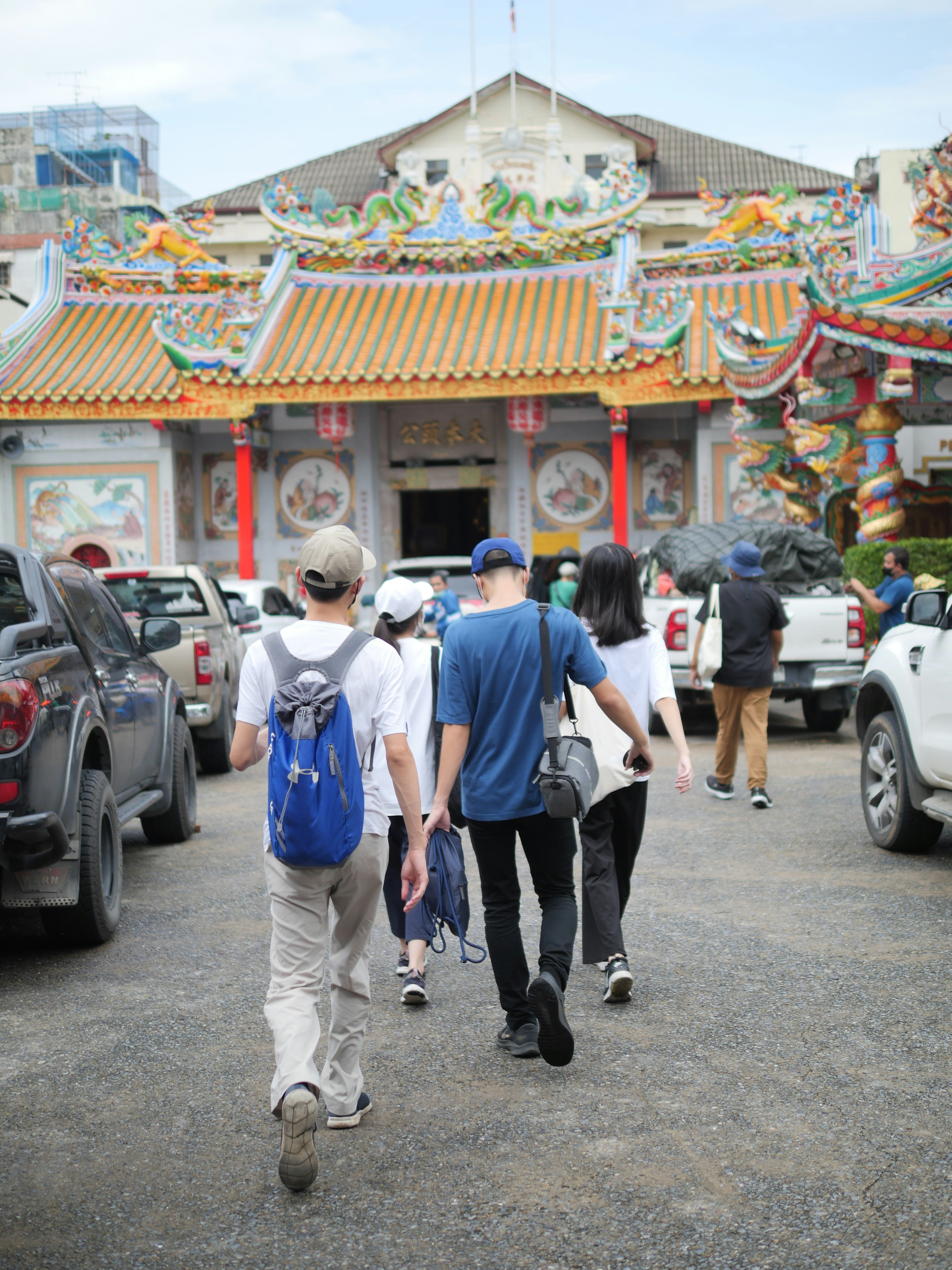 a group of people walking in front of a building with a colorful roof
