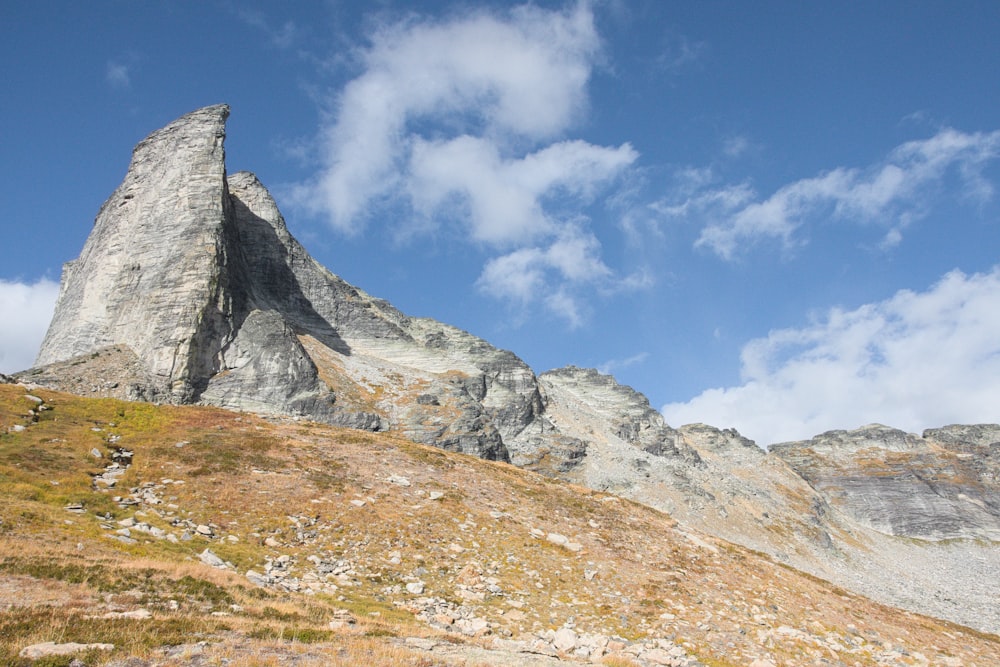 a rocky mountain with a blue sky