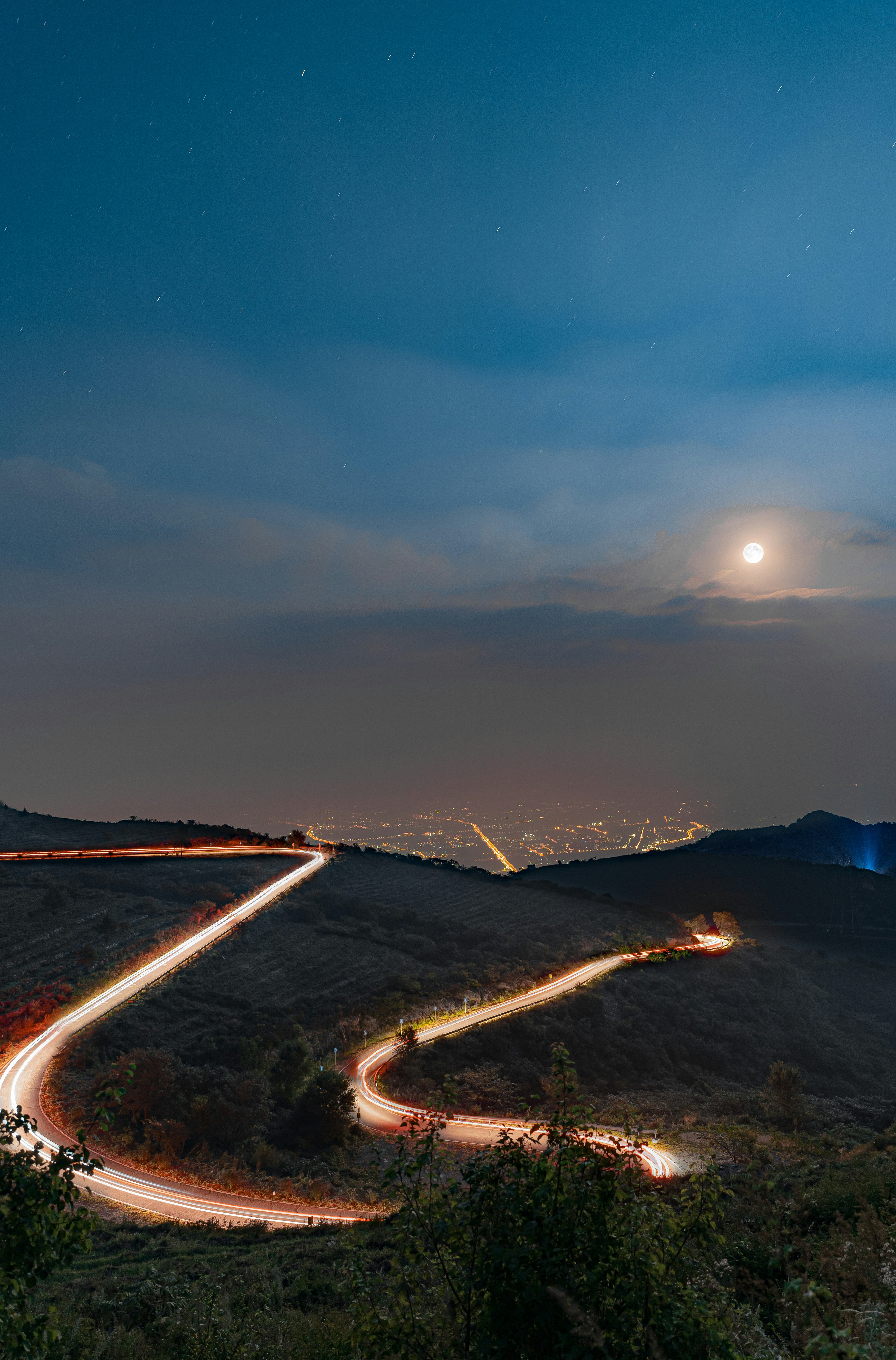 a road with lights on it and a city in the distance