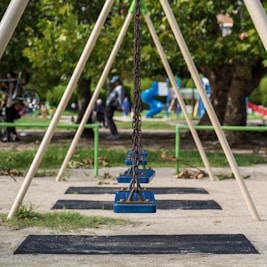 a swing set with people in the background