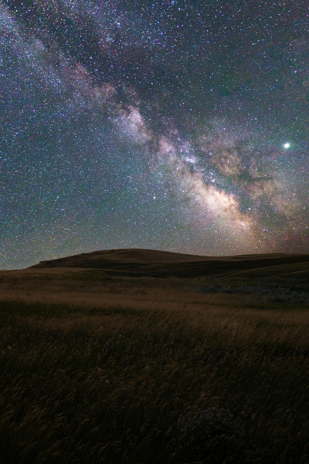 a starry night sky over a mountain