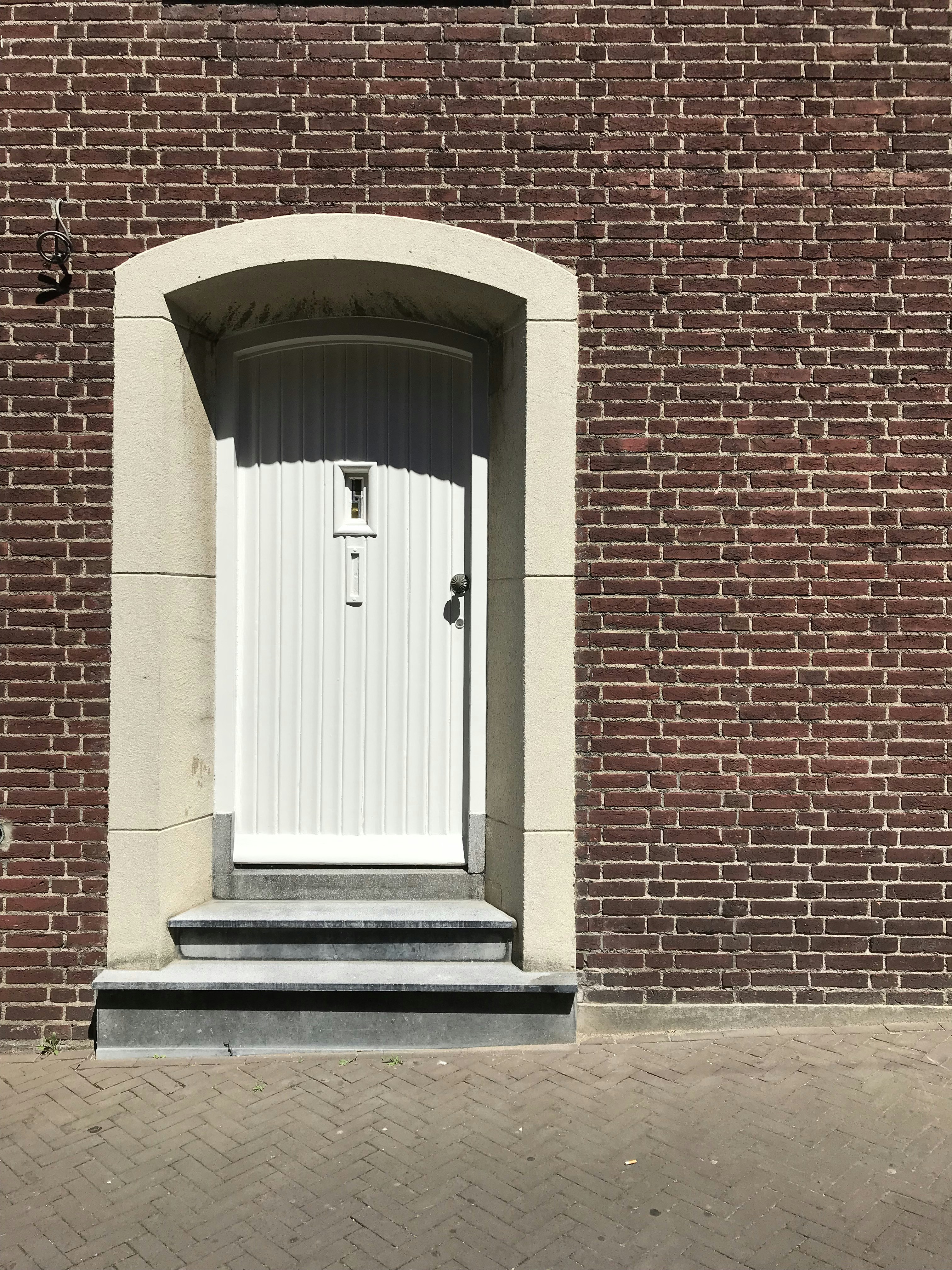 a white door on a brick building