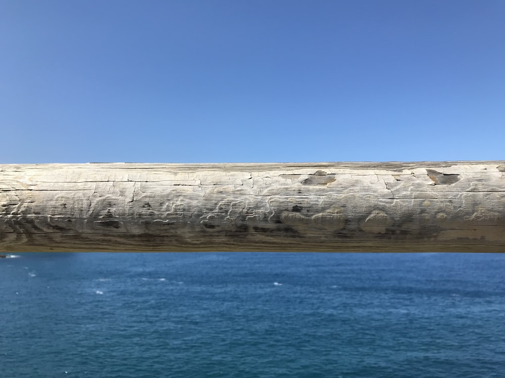 a large stone wall next to a body of water