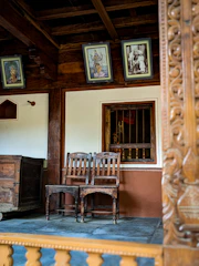Wooden chair and table set in a non-AC room at Mallikarjuna Sadan.