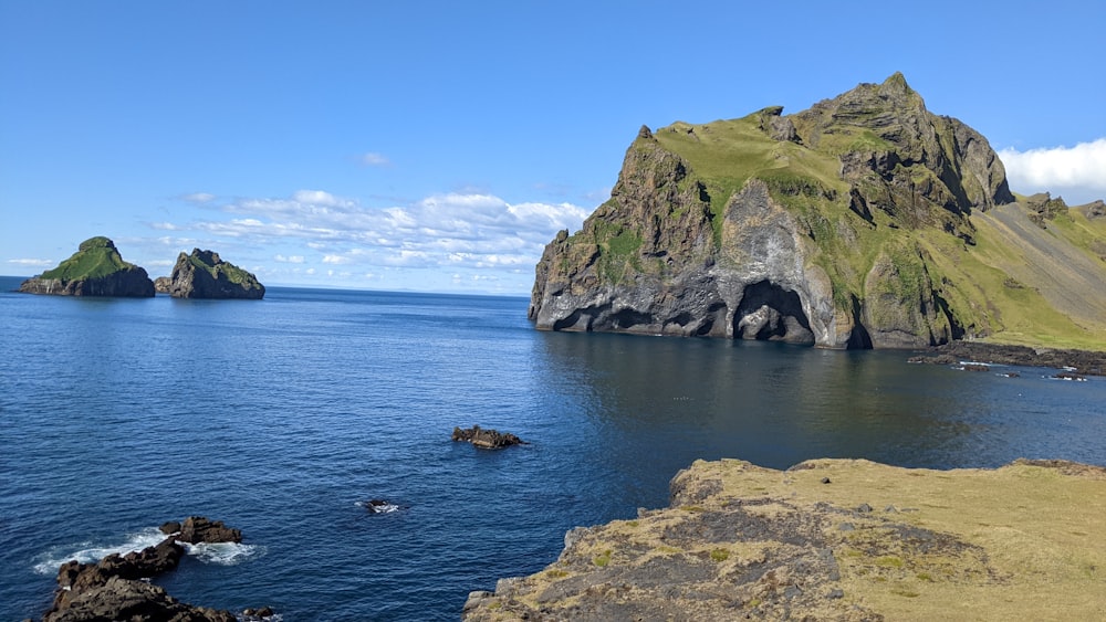 a body of water with rocks and grass on the side