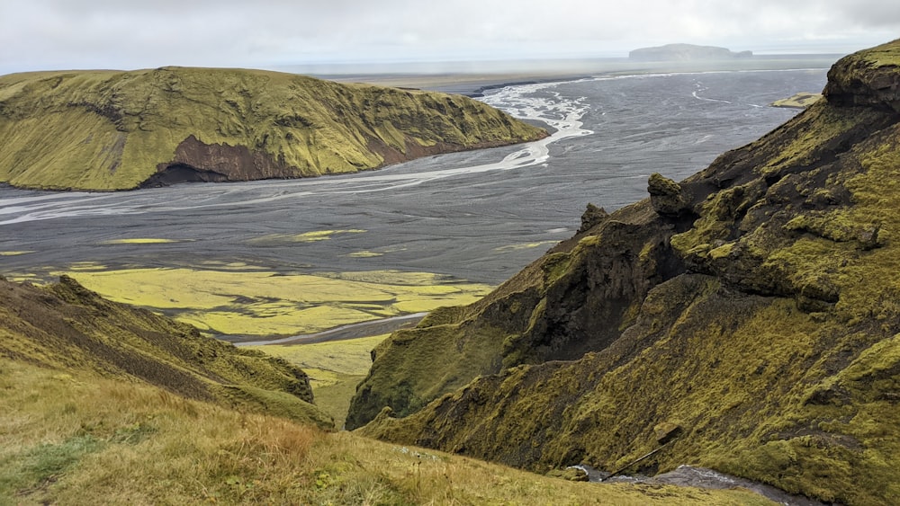 a rocky beach with a body of water in the background