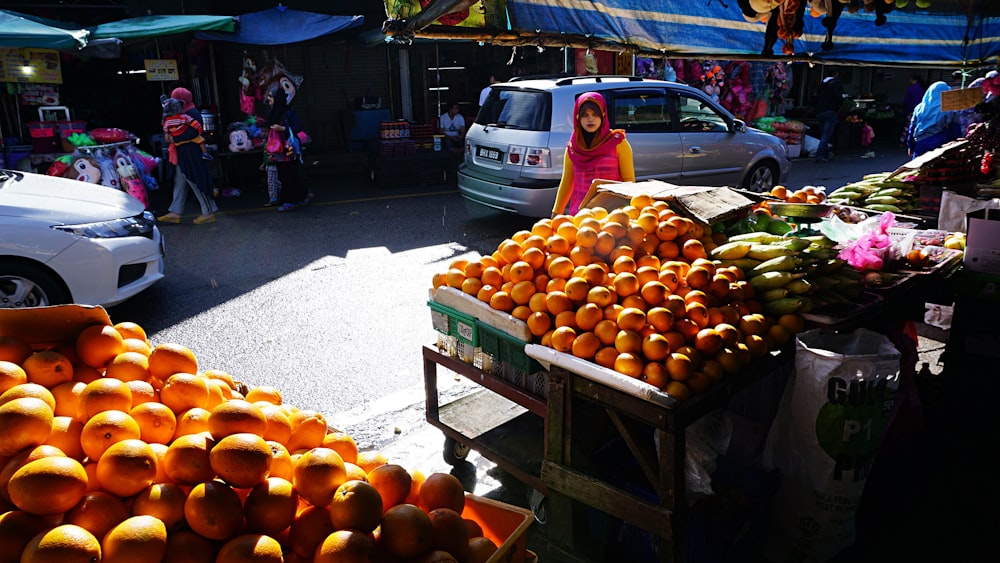 a person stands next to a fruit stand