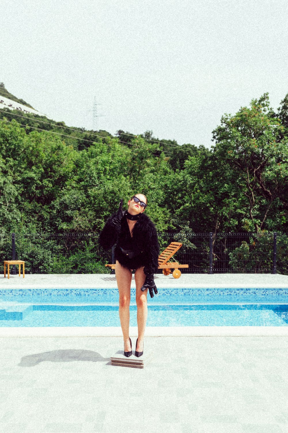 a man standing on a platform by a pool